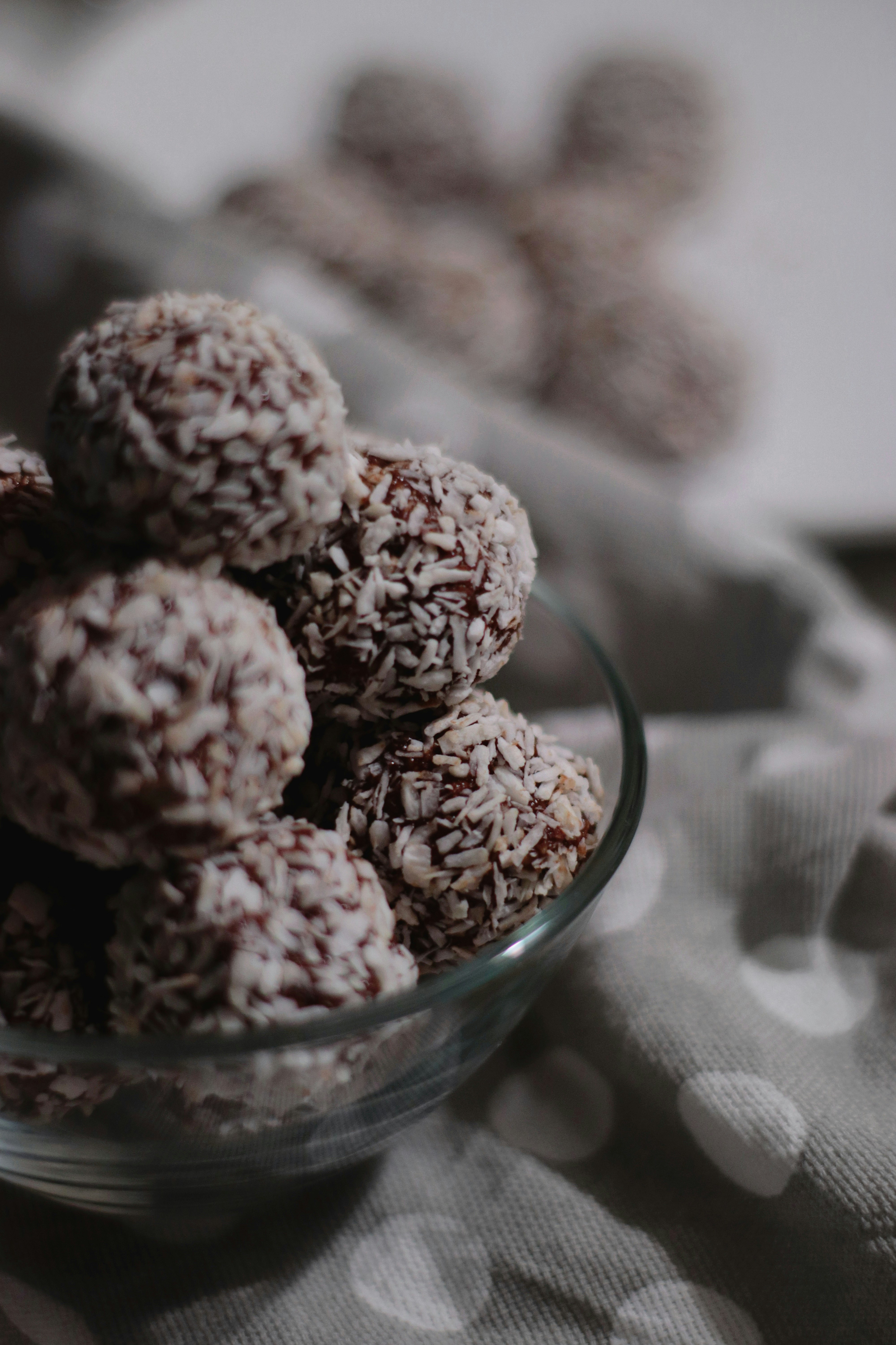 brown and white round fruits in clear glass bowl